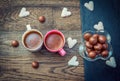 Sweets and cups with coffee on the wooden table